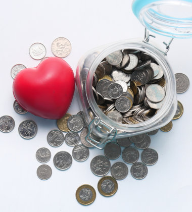 Coins inside a jar and heart shaped squishy beside it