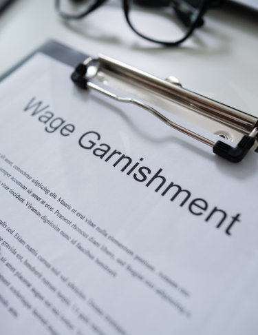 Paper on a clipboard with the words Wage Garnishment printed on it