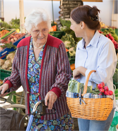 Elderly woman and a younger woman in a market talking