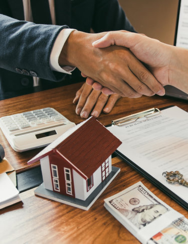 Home sales agents and buyers work on signing new homes and shaking hands