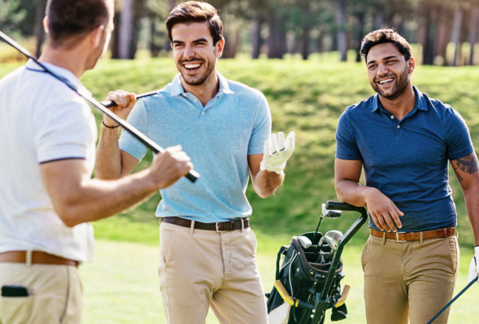 three men smiling and holding golf clubs